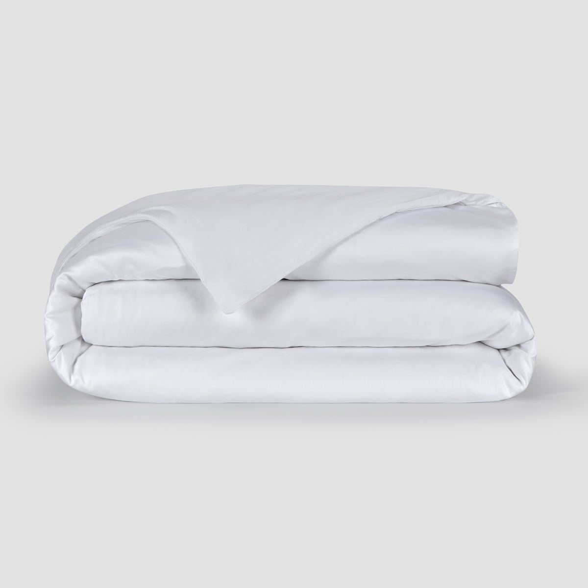 Housse de couette blanche pliée présentant la texture douce du tissu bambou 100% avec boutons cachés en bas