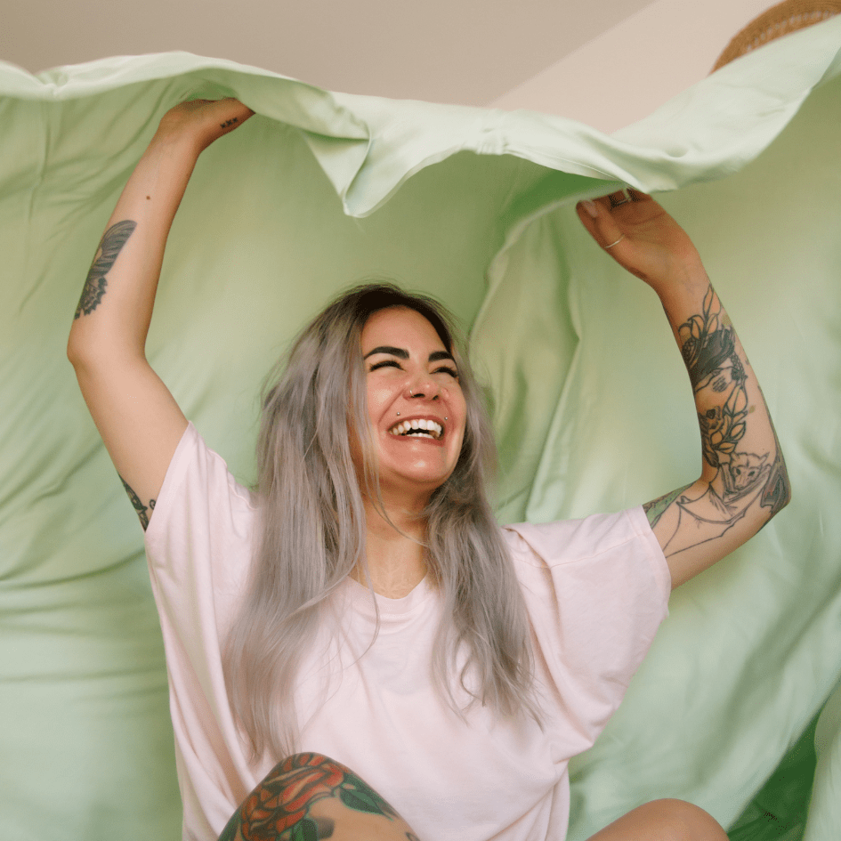 Glimlachende vrouw met groen-wit beddengoed voor comfortabele zomernachten