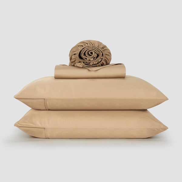 Femme au lit avec draps et oreillers en bambou rose – literie douce, respirante et durable