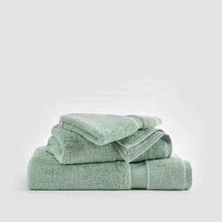 Ensemble de serviettes en bambou Alba vert clair empilées sur fond blanc
