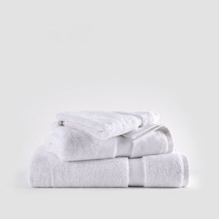 Ensemble de serviettes en bambou blanc empilées montrant serviettes pour le visage, les mains et bain avec bandes texturées.
