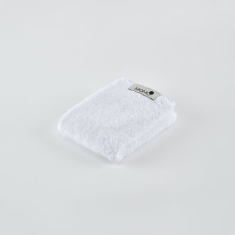 Witte bamboe handdoek met Momo Cotton label op lichte achtergrond, schuine weergave