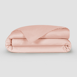 Folded blush pink bamboo duvet cover displayed against neutral background, showing soft fabric texture and construction.