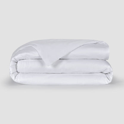 Housse de couette blanche pliée présentant la texture douce du tissu bambou 100% avec boutons cachés en bas