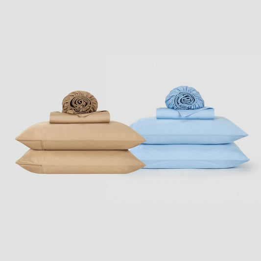 Two stacked bed sheet sets displayed side by side, one in beige and one in light blue, each topped with rolled linens