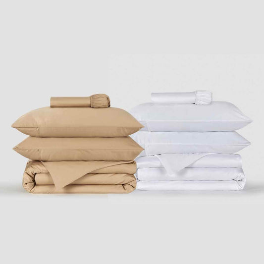 Ensembles de literie beige et blanc empilés soigneusement, avec oreillers et housse de couette Momo Cotton