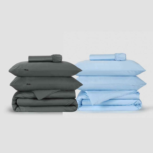 Two duvet cover sets stacked side by side, one charcoal gray and one light blue, displayed against white background