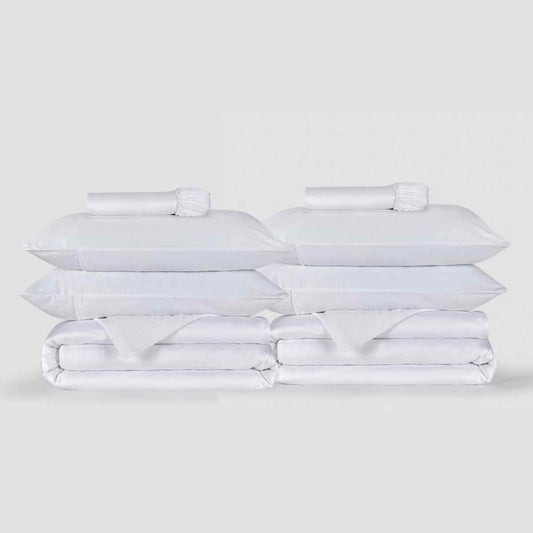 Two white duvet cover sets stacked with pillows and bedding from Momo Cotton displayed against a neutral background