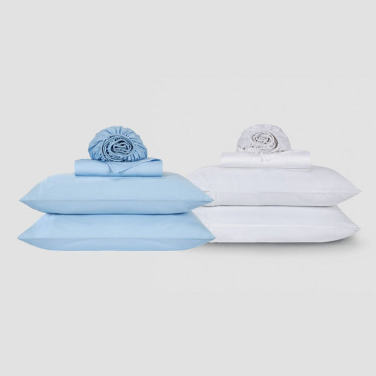Parure de draps bleu et blanc en coton avec oreillers et linge de lit roulé sur fond neutre