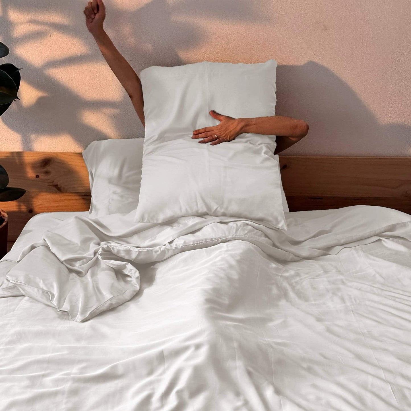 Complete white bamboe beddengoed-set with woman holding pillow – duvet, lakens en kussens, zacht, ademend en duurzaam