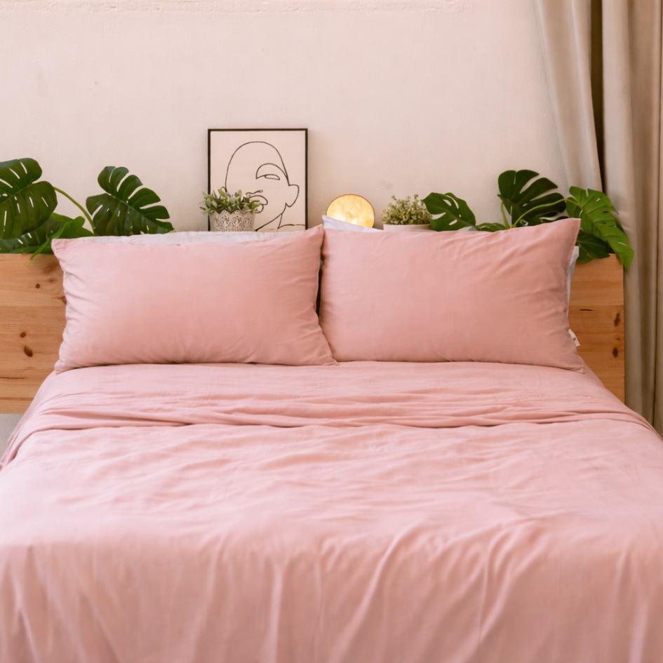 Soft pink bamboe beddengoed neatly made, highlighting the smooth and elegant drape of the fabric.