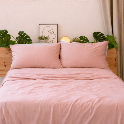 Soft pink bamboe beddengoed neatly made, highlighting the smooth and elegant drape of the fabric.